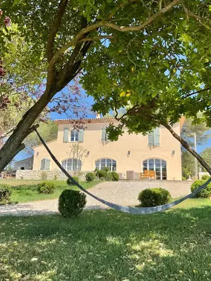 a hammock hanging from a tree in front of a house at La Soleillade Aixoise in Aix-en-Provence