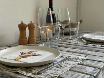 a table with a plate and wine glasses on it at Mas de la Sacristière in Jonquerettes