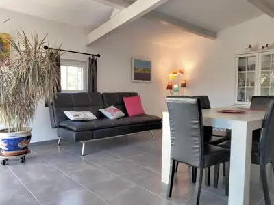 a living room with a couch and a table at Les Platanes in LʼIsle-sur-la-Sorgue