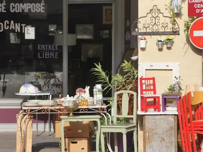 a table and chairs sitting outside of a store at Les Platanes in LʼIsle-sur-la-Sorgue