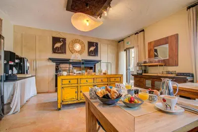 a kitchen with a table with bowls of fruit on it at Hotel Bastide & SPA - Villa de Lourmarin in Lourmarin