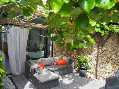 a couch sitting on a deck under a tree at Holiday Home in Pertuis with Private Pool in Pertuis