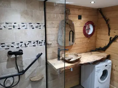 a bathroom with a washing machine and a glass wall at Sortilège in Lambesc