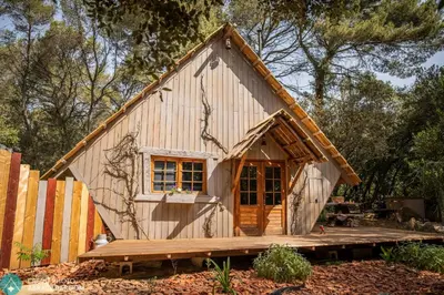 a small wooden house with a wooden deck at Sortilège in Lambesc