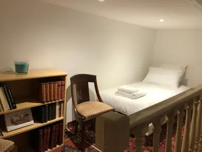a small room with a bed and a chair at Villa du defens in Saint-Martin-de-Castillon
