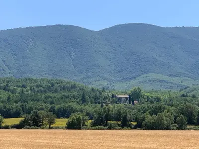 a house in a field with mountains in the background at Villa du defens in Saint-Martin-de-Castillon