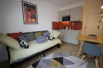 a living room with a couch and a kitchen at Le Petit Marius in Aix-en-Provence