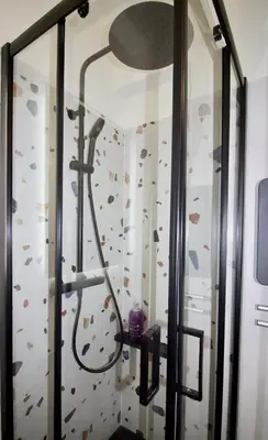 a shower in a room with a rock wall at Le Petit Marius in Aix-en-Provence