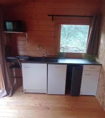 a kitchen with a sink and a window in a cabin at Charmant chalet à Cornillon-Confoux avec piscine partagée in Cornillon-Confoux