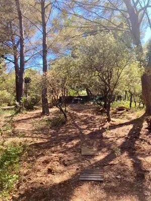 a dirt path with trees and a bench in a park at Charmant chalet à Cornillon-Confoux avec piscine partagée in Cornillon-Confoux