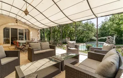 an outdoor patio with wicker furniture and a glass table at 4 Bedroom Pet Friendly Home In Apt in Apt