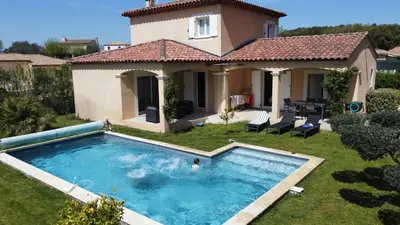 a villa with a swimming pool in front of a house at Villa Noa Pertuis in Pertuis