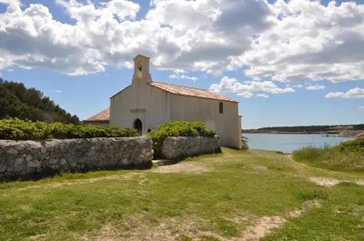 an old church next to a wall and a body of water at Villa Noa Pertuis in Pertuis