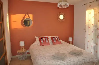 a bedroom with a bed with orange walls at Villa Noa Pertuis in Pertuis
