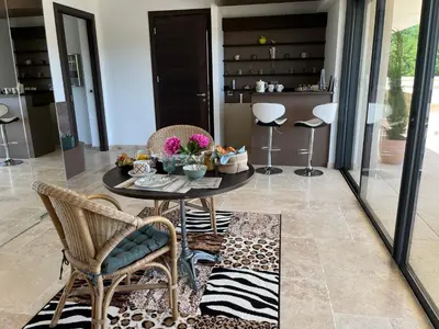 a dining room with a table and chairs and a kitchen at Domaine des Eucalyptus in Mollégès