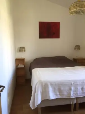 a bedroom with a bed and a painting on the wall at Gîte Coquelicots in Montsalier