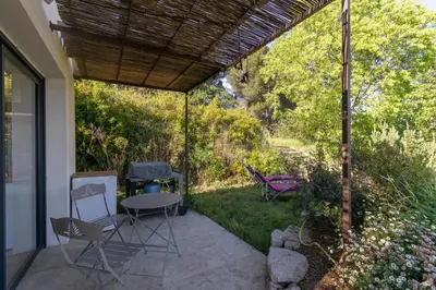 a patio with chairs and a table and a roof at Terre Luberon in Pertuis