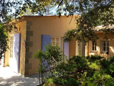 a house with a blue door and trees at Maisonnette dans le Luberon - Bois Romay in La Bastide-des-Jourdans