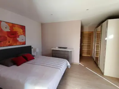 a bedroom with a white bed and a painting on the wall at JULIANA in Eyragues