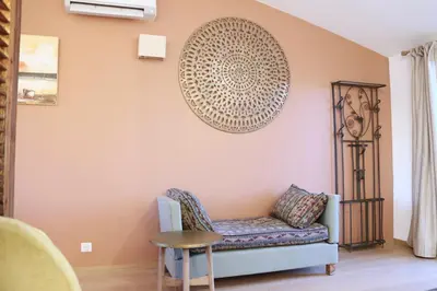 a living room with a couch and a plate on the wall at Le Jardin d'Érables St Remy 7 HA Piscine/Clim in Paluds de Noves