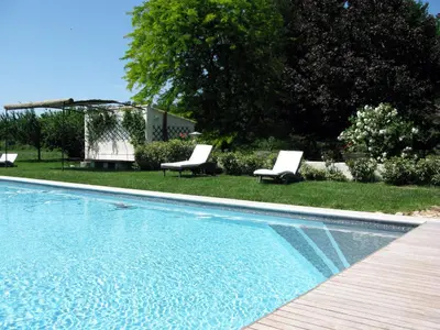 a swimming pool with two lounge chairs next to a yard at Le Jardin d'Érables St Remy 7 HA Piscine/Clim in Paluds de Noves