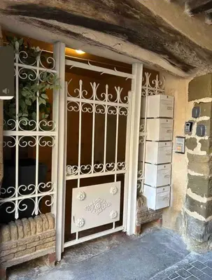 a building with a gate on the front of a window at Appartement Proche Quai Rouget in LʼIsle-sur-la-Sorgue