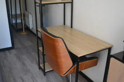 a wooden table and a chair in a room at Appartement Proche Quai Rouget in LʼIsle-sur-la-Sorgue