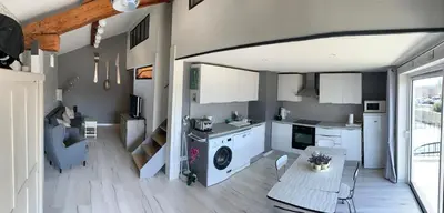 a kitchen and living room with a washing machine at Clos du Cardinal in LʼIsle-sur-la-Sorgue