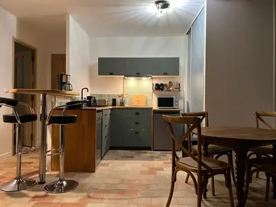 a kitchen with a table and a table and chairs at Appartement Mas de Silvacane in La Roque-dʼAnthéron