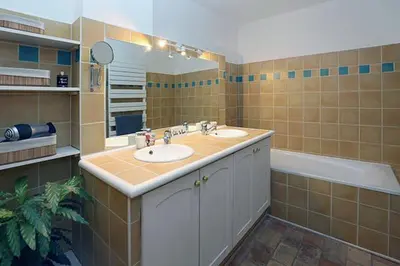 a bathroom with two sinks and a mirror and a tub at Appartement Mas de Silvacane in La Roque-dʼAnthéron