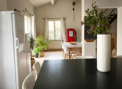 a kitchen with a table and a dining room with a refrigerator at Belle maison provençale au pied du Mont Ventoux in Caromb