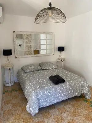 a bed in a bedroom with two tables and two lamps at La tour 2: Appart neuf au cœur de la petite venise in LʼIsle-sur-la-Sorgue