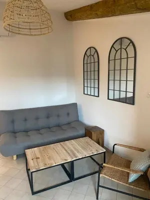 a living room with a blue couch and a table at La tour 3: Appart au cœur de la petite Venise in LʼIsle-sur-la-Sorgue
