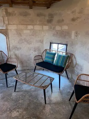 a room with three chairs and a table and a couch at La tour 3: Appart au cœur de la petite Venise in LʼIsle-sur-la-Sorgue