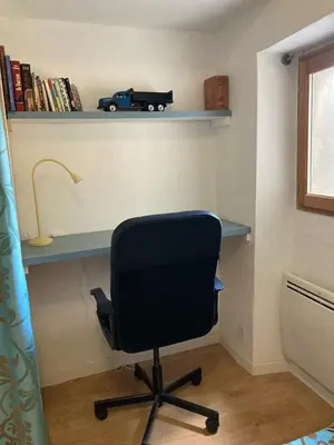 a desk with a black chair and a truck on a shelf at Pélissanne, superbe appartement entièrement rénové in Pélissanne