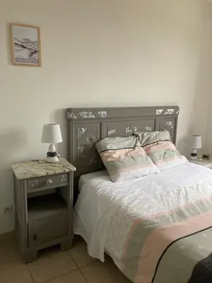 a bedroom with a bed and a side table with a lamp at Les Oliviers in Mallemort