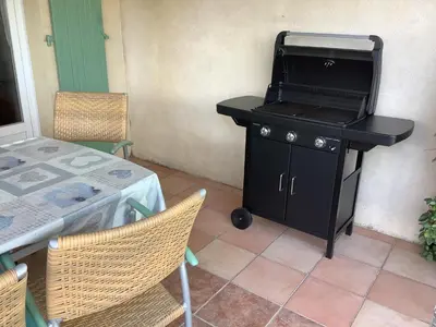 a barbecue grill sitting on a table in a patio at Les Oliviers in Mallemort