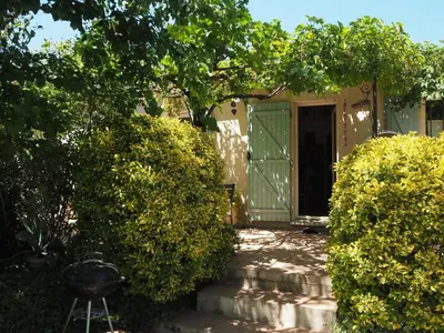 a house with a green door and some bushes at Cozy Vacation House with Pool, Vernègues in Vernègues