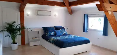 a bedroom with a blue bed and a window at Maison calme et rénovée 