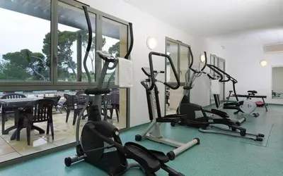 a gym with several exercise bikes in a room at appartement cosy avec climatisation réversible GOLF DE SAUMANE in Saumane-de-Vaucluse