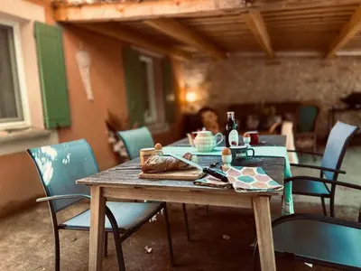 a wooden table with a plate of food on it at Domaine Plan des Devens in Roussillon