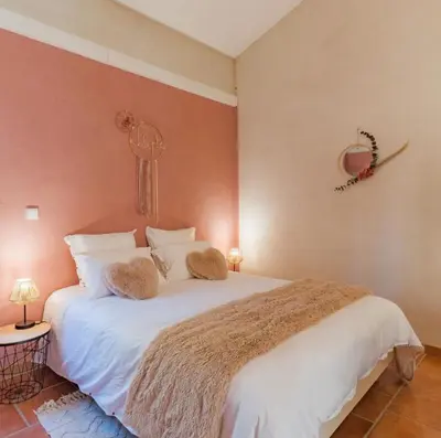 a bedroom with a large white bed with two pillows at Domaine Plan des Devens in Roussillon