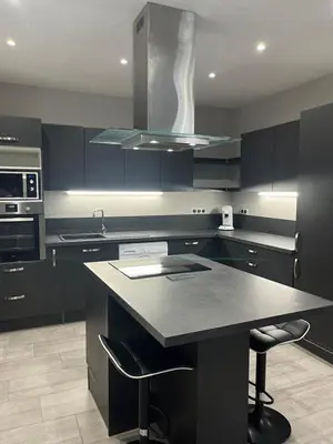 a kitchen with black cabinets and a black counter top at Logement privé à proximité du Mont Ventoux in Carpentras