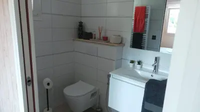a white bathroom with a toilet and a sink at Le Nid'Isle - Stationnement privé gratuit - Wi-Fi performant - Climatisation in LʼIsle-sur-la-Sorgue