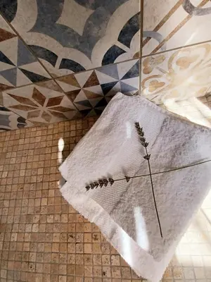 a white towel on the floor in a bathroom at Bastide Cedrea in Peyrolles-en-Provence