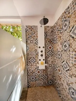 a bathroom with mosaic tiles on the wall at Bastide Cedrea in Peyrolles-en-Provence