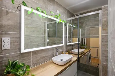 a bathroom with two sinks and a mirror at Woods Natural Hyper centre Fontaine Moussue in Salon-de-Provence
