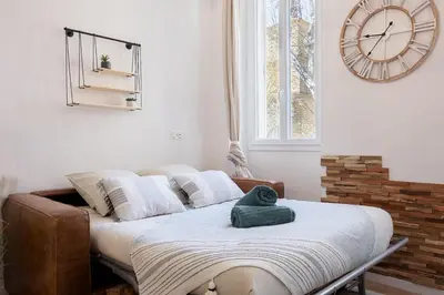 a room with a bed with a clock on the wall at Woods Natural Hyper centre Fontaine Moussue in Salon-de-Provence