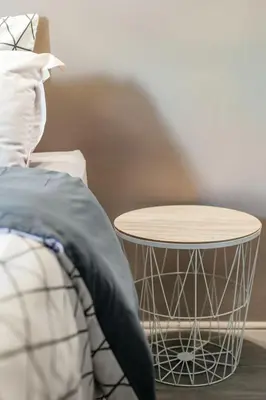 a side table next to a bed with a pillow at appartement de charme dans le luberon in Lagnes