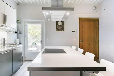 a kitchen with a white counter top and a table at appartement de charme dans le luberon in Lagnes